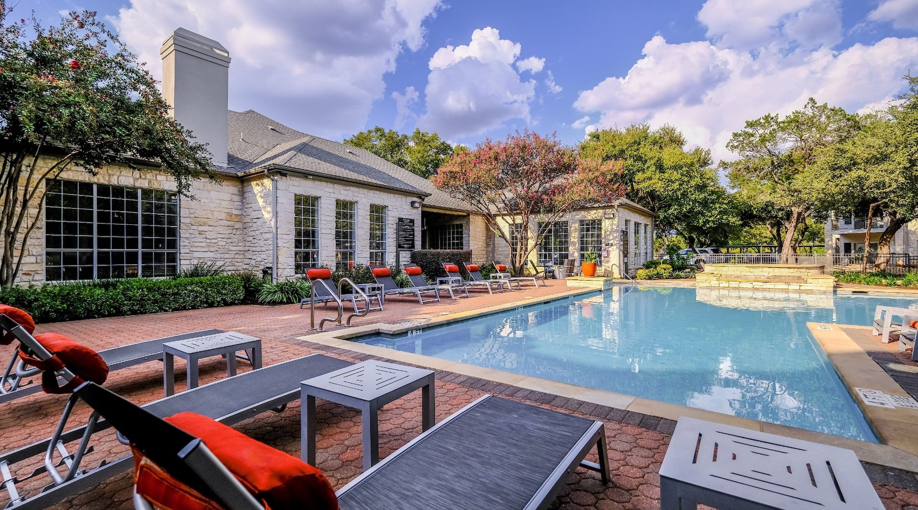 a swimming pool in front of a brick building