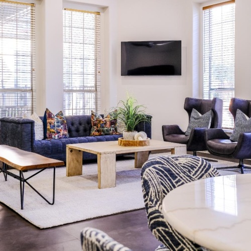 Enjoy our resident-only features living room area with a tv and couches in clubhouse