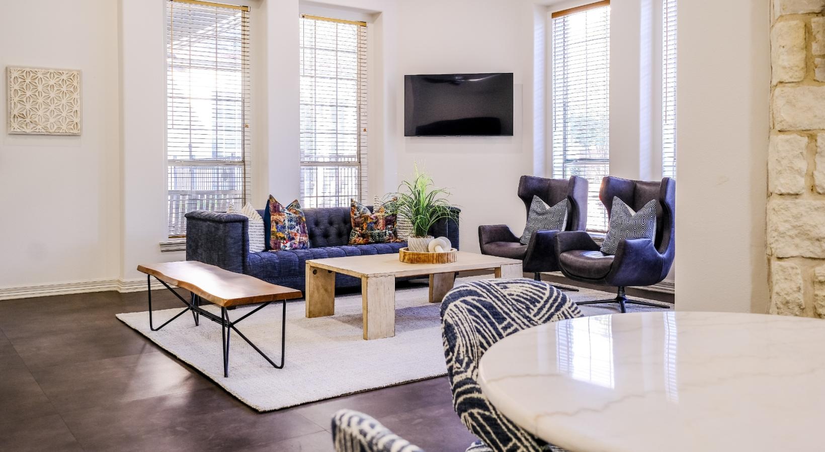 Enjoy our resident-only features living room area with a tv and couches in clubhouse