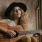 woman with long hair and a hat playing a guitar