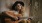 woman with long hair and a hat playing a guitar