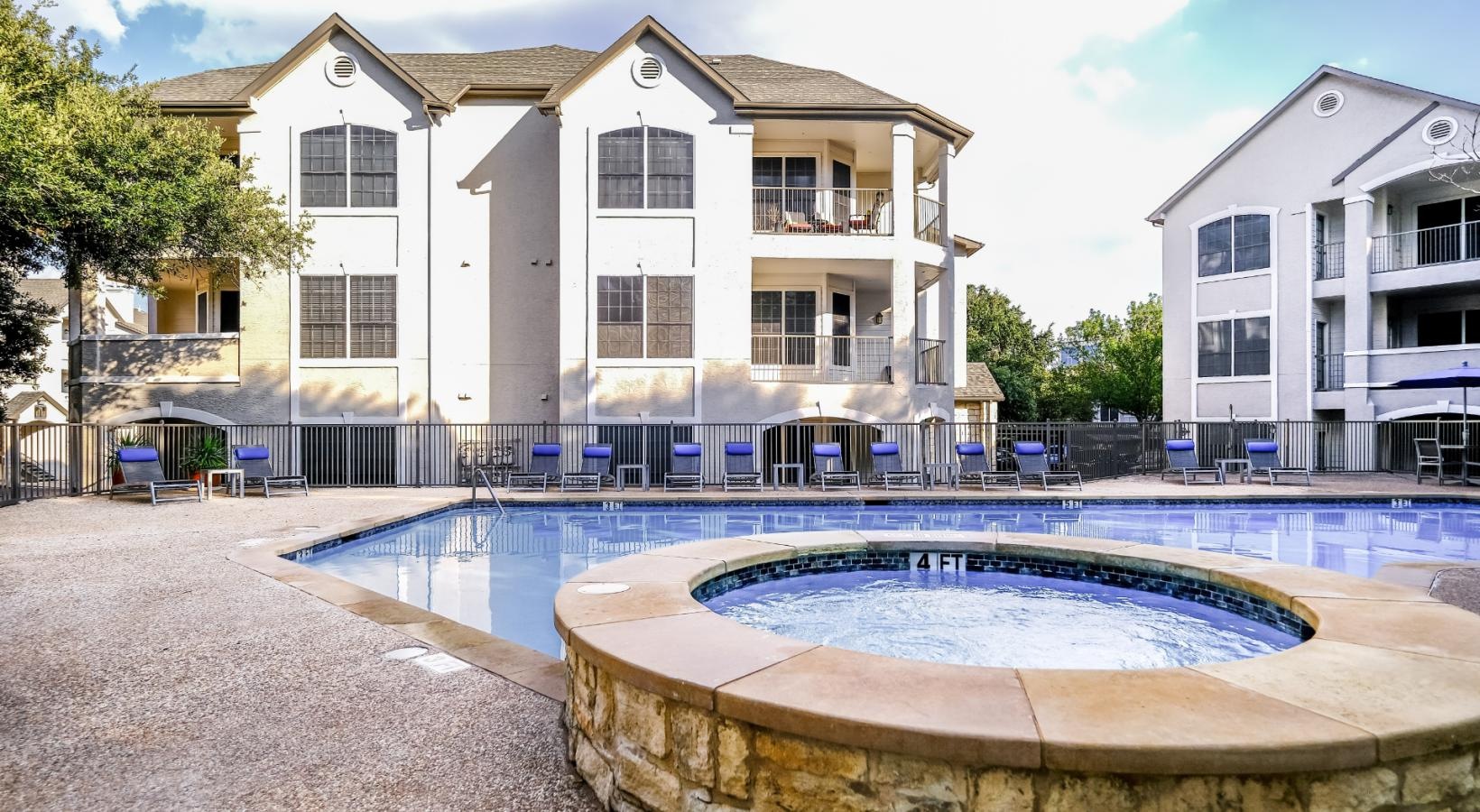 Resort-style swimming pool jacuzzi next to swimming pool